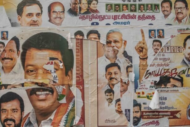 Political posters are plastered on a wall.