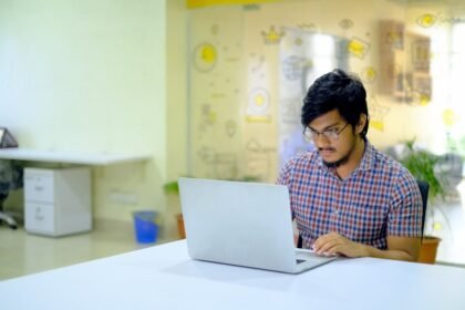 woman in blue and white checkered shirt using macbook