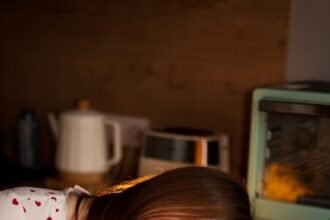 A tired woman rests with coffee at the table.